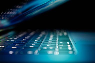 photo of a laptop keyboard bathed in blue light
