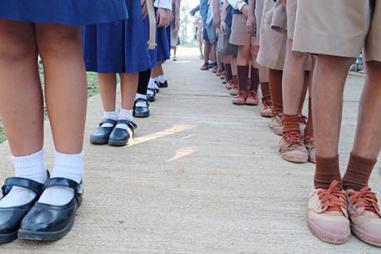 photograph of school children's feet standing in line in India