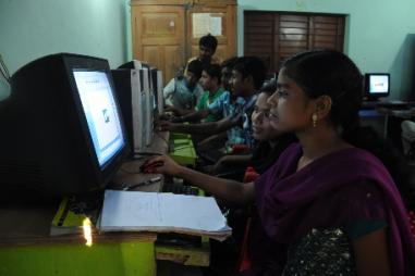 Photo of a number of young, Indian, men and women working at computers