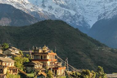 photograph of a village in the hills in Nepal with Mount Everest in the background